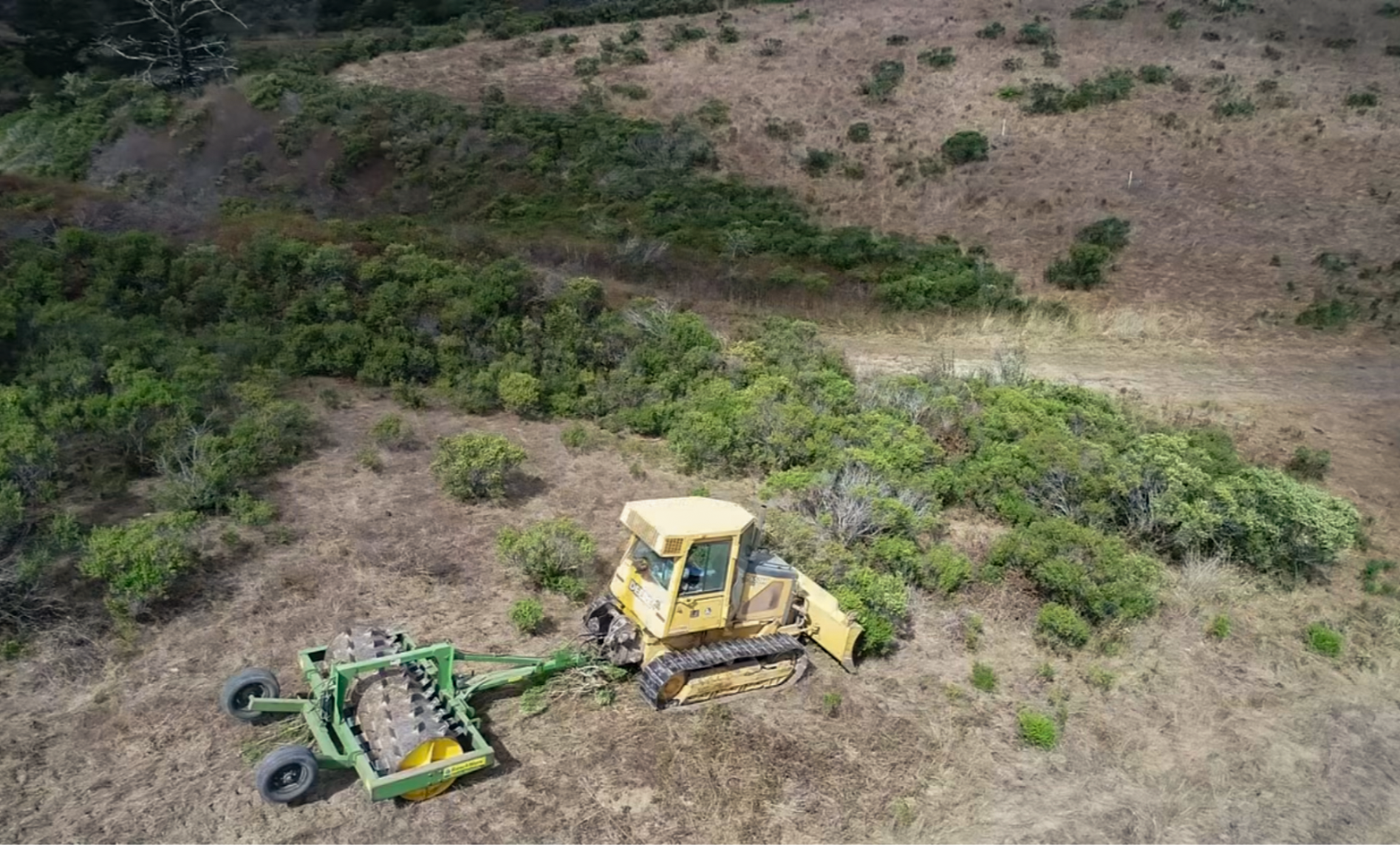 Shannon Waldron, Land & Livestock Assistant at TomKat Ranch, driving the bulldozer pulling the brush crusher.